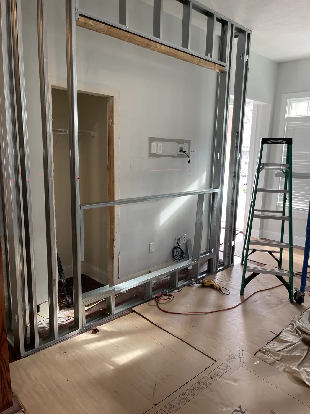 Before — Steel-stud framing to a finished porcelain fireplace feature wall