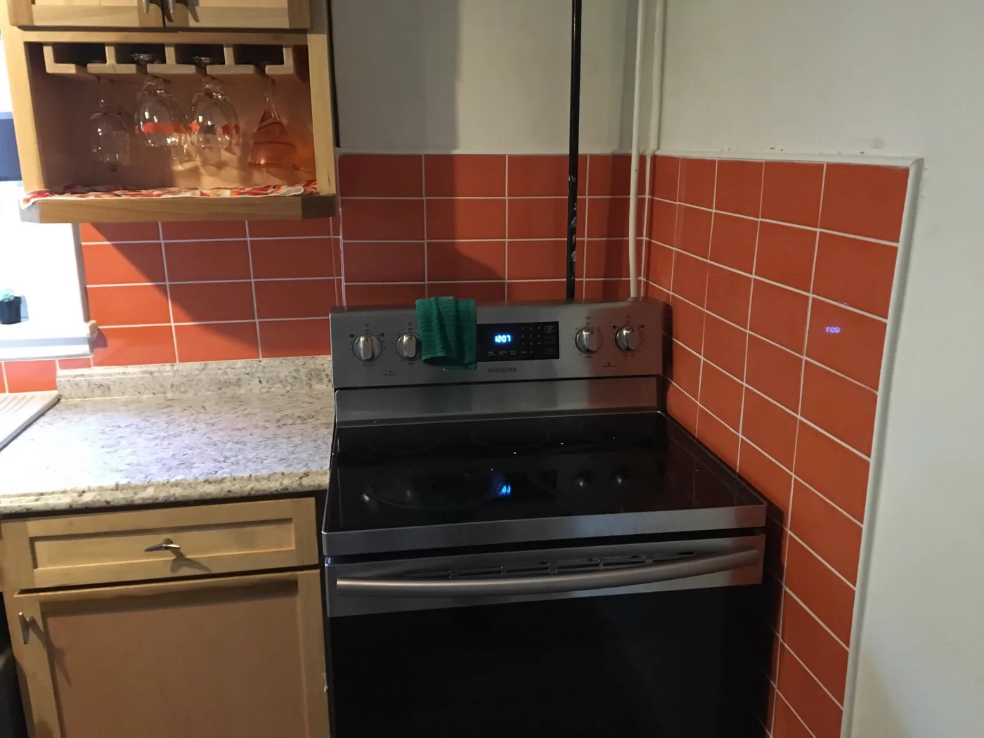 After — Bare kitchen wall to a fresh terracotta tile backsplash