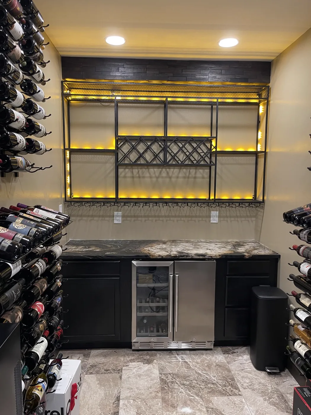 Custom wine cellar — lit racking & stone floor